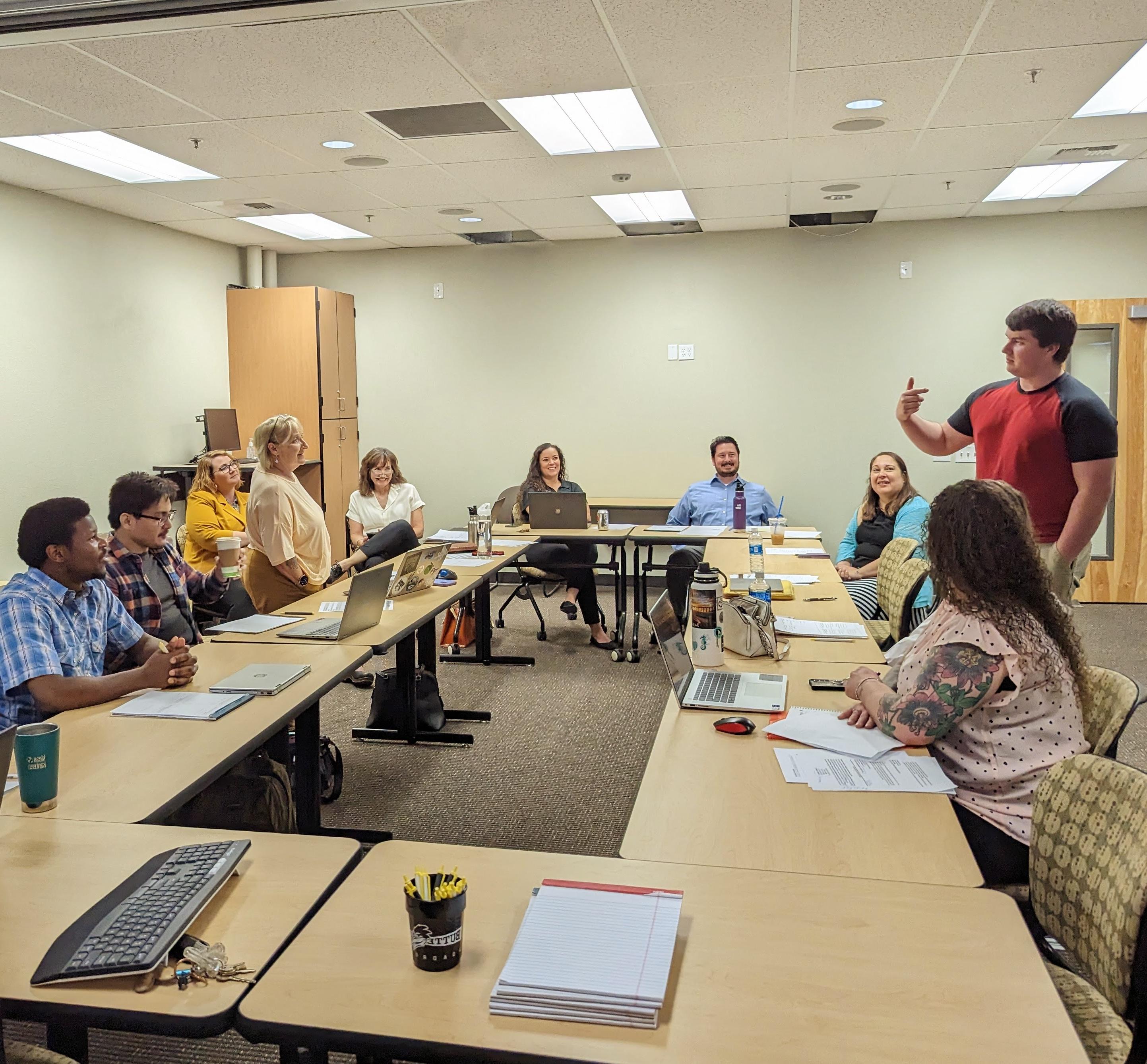 a student speaks to a group of hiring managers seated around a table.