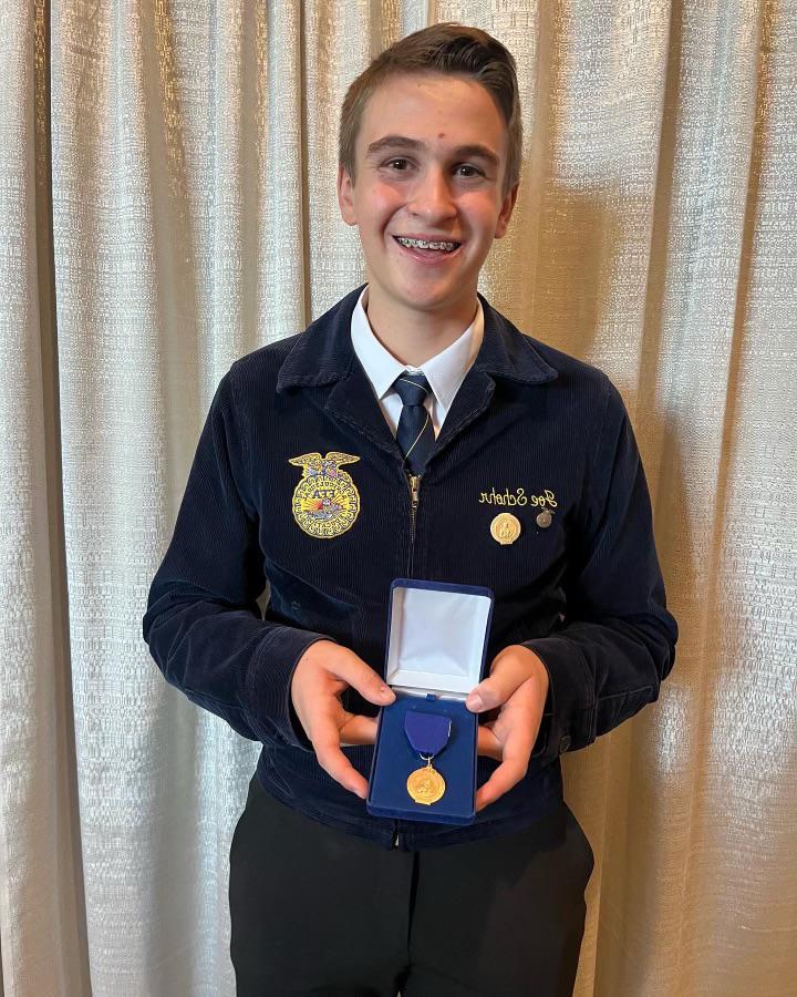 A student Holding an award infront of him. 